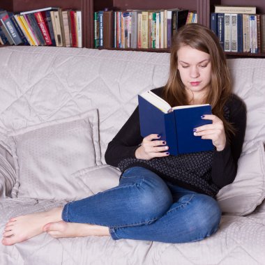 Kadın kütüphanede kitap okuma
