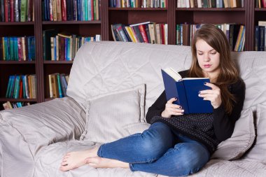 Kadın kütüphanede kitap okuma