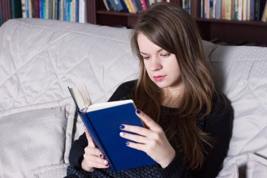Kadın kütüphanede kitap okuma