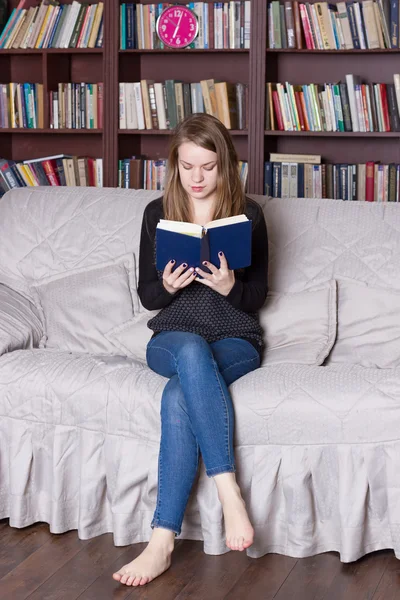 Женщина в библиотеке читает книгу — стоковое фото
