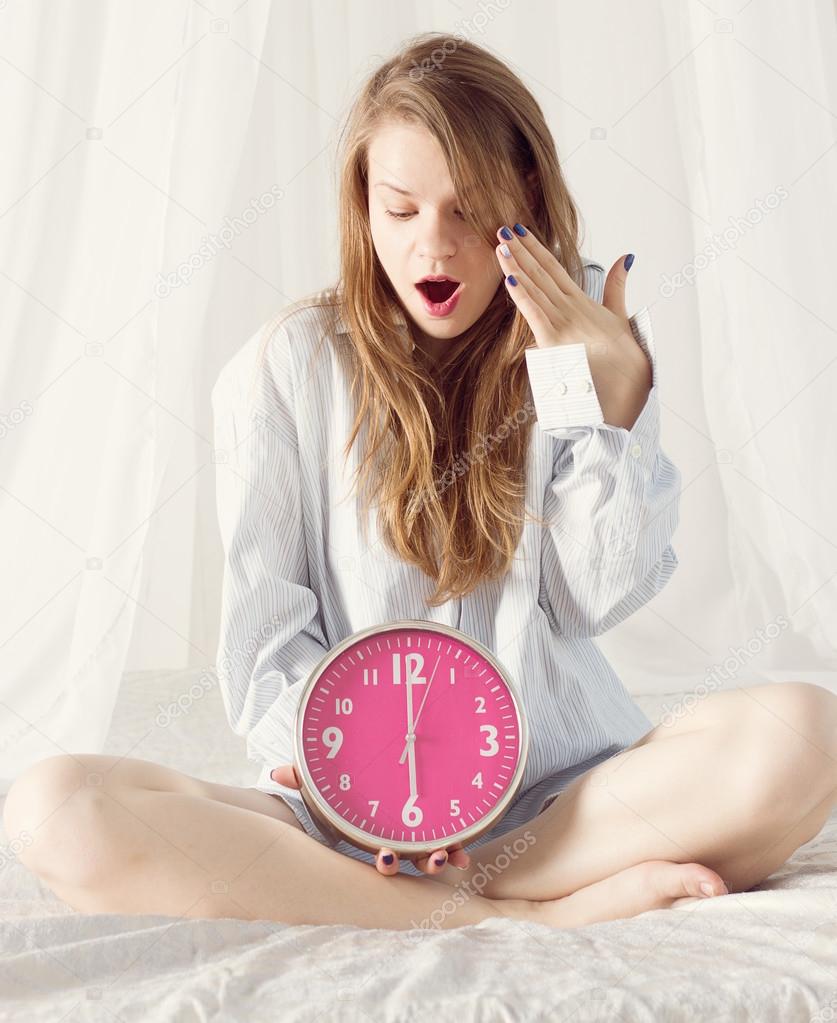 girl with big pink clock the morning in bed