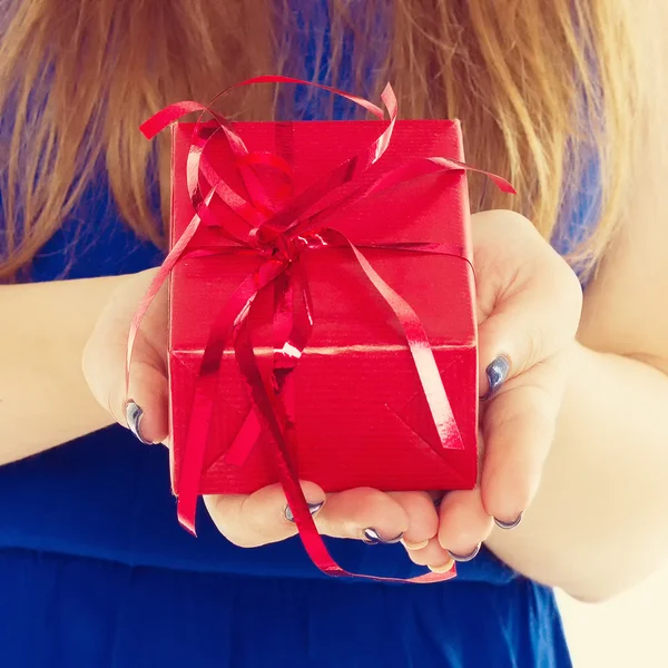 Red gift box with hands of a young woman — Stock Photo, Image