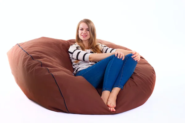 Chica sentado en un braun beanbag silla . — Foto de Stock