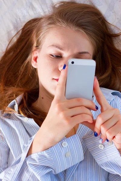 Žena odesílání textu s mobilním telefonem v posteli — Stock fotografie