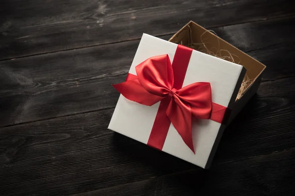 Witte geschenkdoos met rood lint — Stockfoto