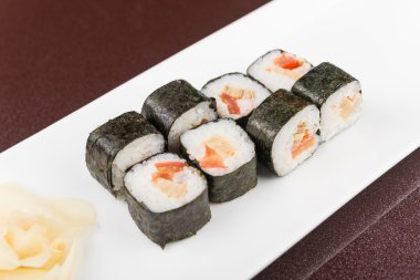 Suşi beyaz tabakta yuvarlanıyor.