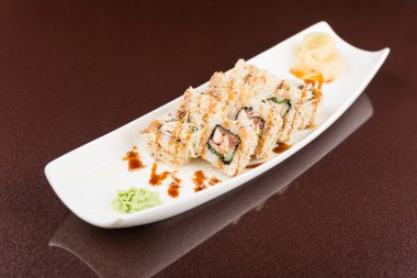 Suşi beyaz tabakta yuvarlanıyor.