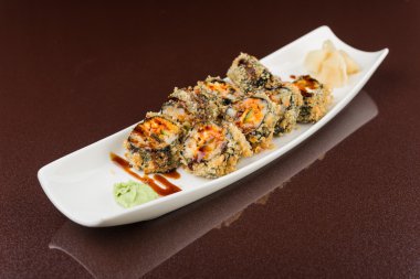 Suşi beyaz tabakta yuvarlanıyor.