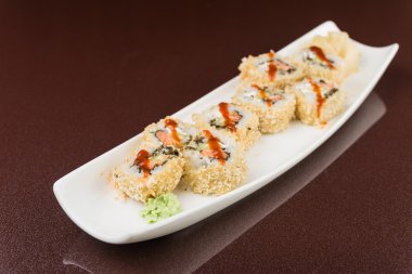 Suşi beyaz tabakta yuvarlanıyor.