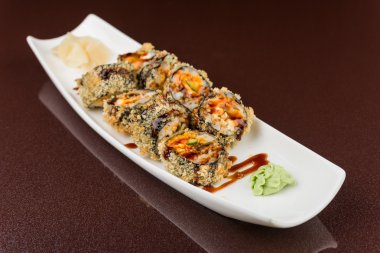 Suşi beyaz tabakta yuvarlanıyor.