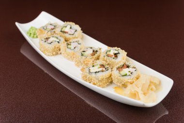 Suşi beyaz tabakta yuvarlanıyor.