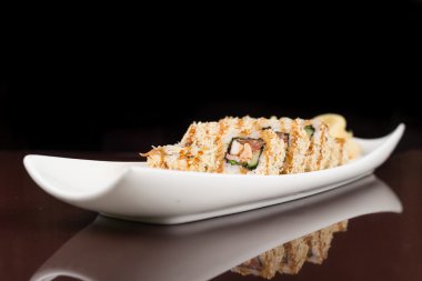 Suşi beyaz tabakta yuvarlanıyor.