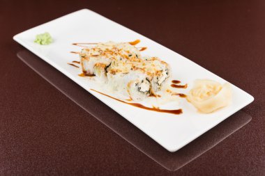 Suşi beyaz tabakta yuvarlanıyor.