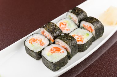 Suşi beyaz tabakta yuvarlanıyor.