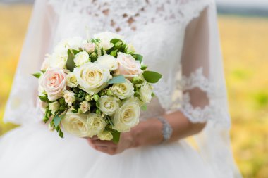 Düğün buketi ellerinde.