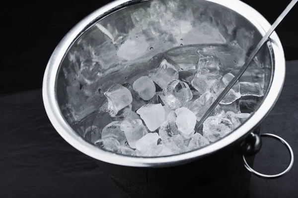 黒を背景にシャンパンの入ったバケツの中の氷のキューブ — ストック写真
