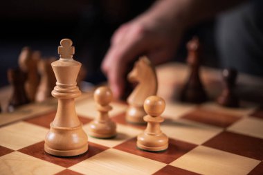 Bir arkadaşla akşam satranç oyunu. Oyunun ortasında. Satranç oyuncusu düşünür ve hamle yapar..