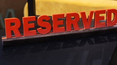 Restoran masasında servis rezervasyonu. Ahşap harfli büyük kırmızı bir plaket..