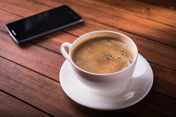 Koffiekopje en telefoon — Stockfoto
