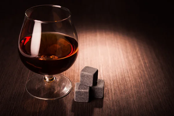 Cognac glass on wooden table — Stock Photo, Image