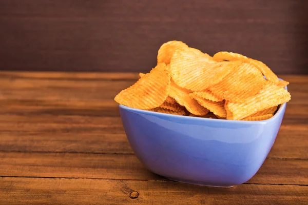 Potato chips in blue plate — Stock Photo, Image