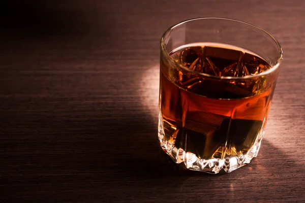 Whiskey beverage in glass with stone — Stock Photo, Image