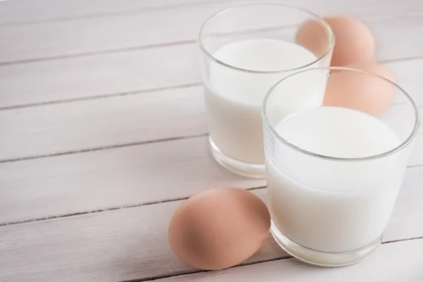 Glass of milk and eggs — Stock Photo, Image
