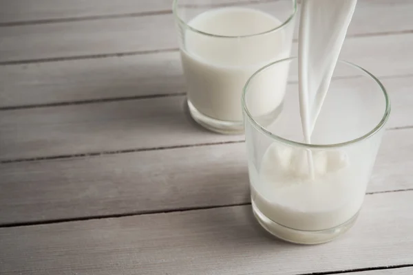 Pouring fresh milk into glass — Stock Photo, Image