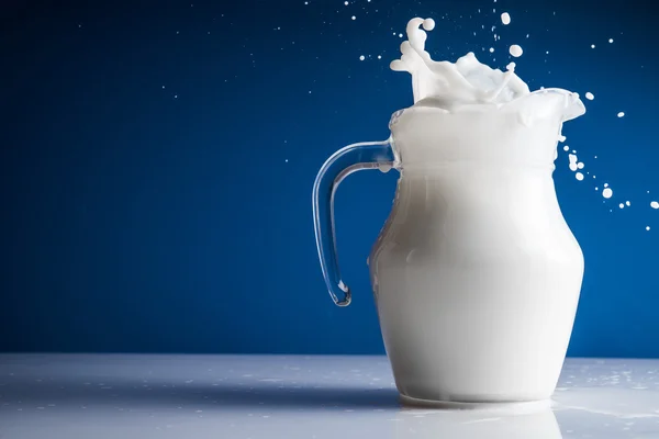 Carafe with milk splash — Stock Photo, Image