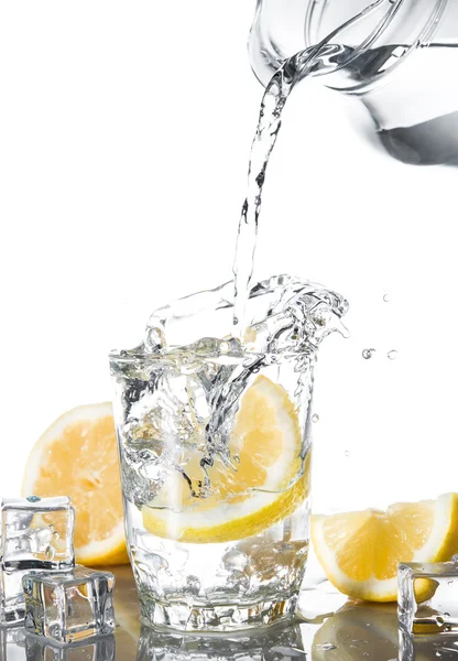 Pour water in glass with lemon — Stock Photo, Image