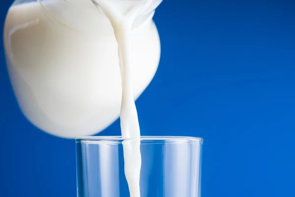 Pouring fresh milk into glass — Stock Photo, Image