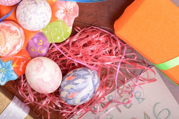 Pasqua con uova nel nido e tulipani gialli sul tavolo di legno blu. Vista dall'alto — Foto Stock