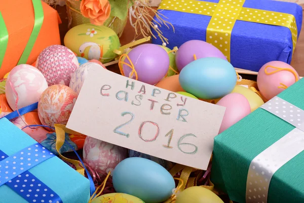 Arreglo de cajas de regalo en papel de envolver con cintas a cuadros y huevos de Pascua decorados aislados sobre fondo blanco —  Fotos de Stock