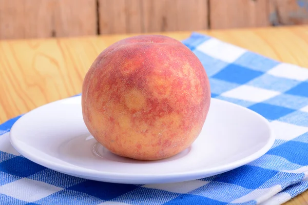 Färsk persika på vit platta — Stockfoto