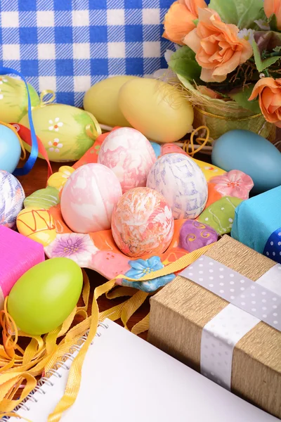 Easter background with colorful eggs and yellow tulips over white wood. Top view with copy space — Stock Photo, Image