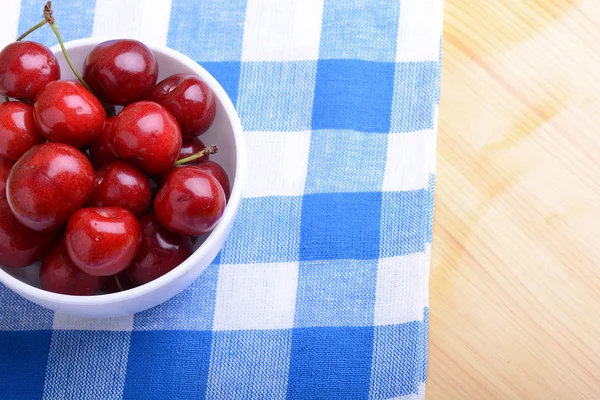 Röda mogna körsbär i en vit skål — Stockfoto