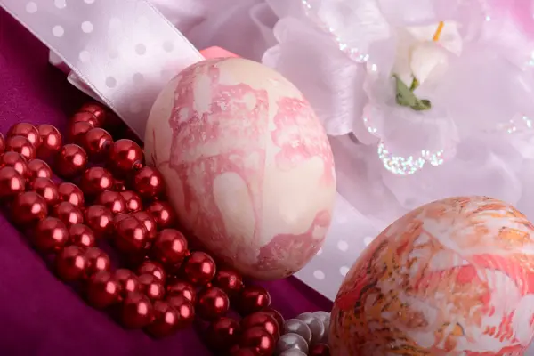 Painted Easter eggs decorated with flowers with pearls in a basket on an old table — Stock Photo, Image