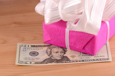 Bir hediyeyle birlikte dolar parası, krizin sembolü, satış, stoklama ve zenginliğin sembolü. Tahta arka planda Amerikan parası.
