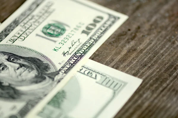 Close-up of a 100 dollars banknotes on wooden background — Stock Photo, Image