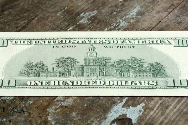 Close-up of a 100 dollars banknotes on wooden background