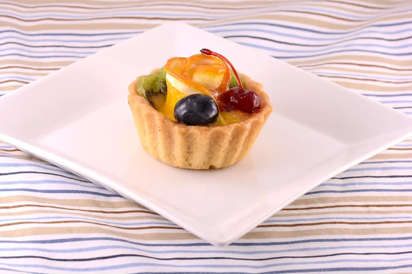 Pastel de chocolate con cereza y oliva en plato blanco —  Fotos de Stock