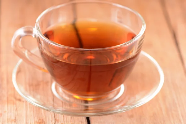 Una taza de té sobre fondo de madera — Foto de Stock