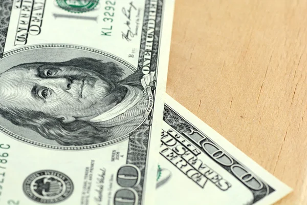 Közeli kép: egy 100 dolláros bankjegyet fából készült háttér — Stock Fotó