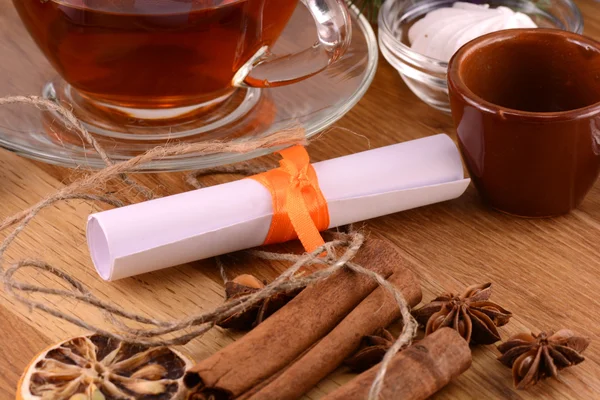 Tea cup with white paper and cinnamon — Stock Photo, Image