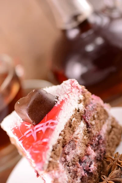 Bolo com coração de chocolate e garrafa de vidro — Fotografia de Stock