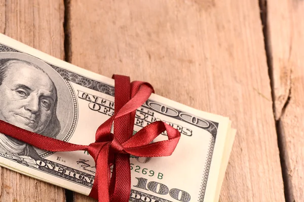 Dollar wraped upp med ett rött band isolerad på vit bakgrund — Stockfoto