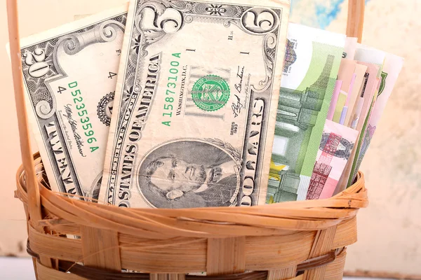 Dinheiro colocado em uma cesta, dólares, euro e dinheiro ucraniano — Fotografia de Stock