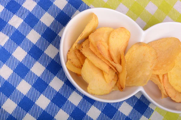 Крупный план свежих, хрустящих картофельных чипсов в деревянной миске на белом фоне . — стоковое фото