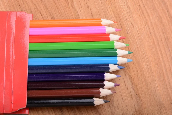 Colored pencils on wooden background Royalty Free Stock Photos