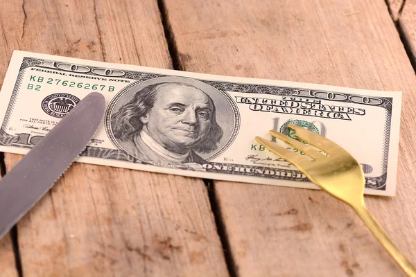 American money on wooden plate with knife and fok Stock Image